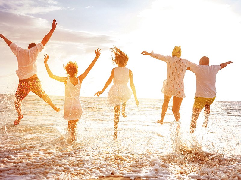 Several people jumping over the water in the sea