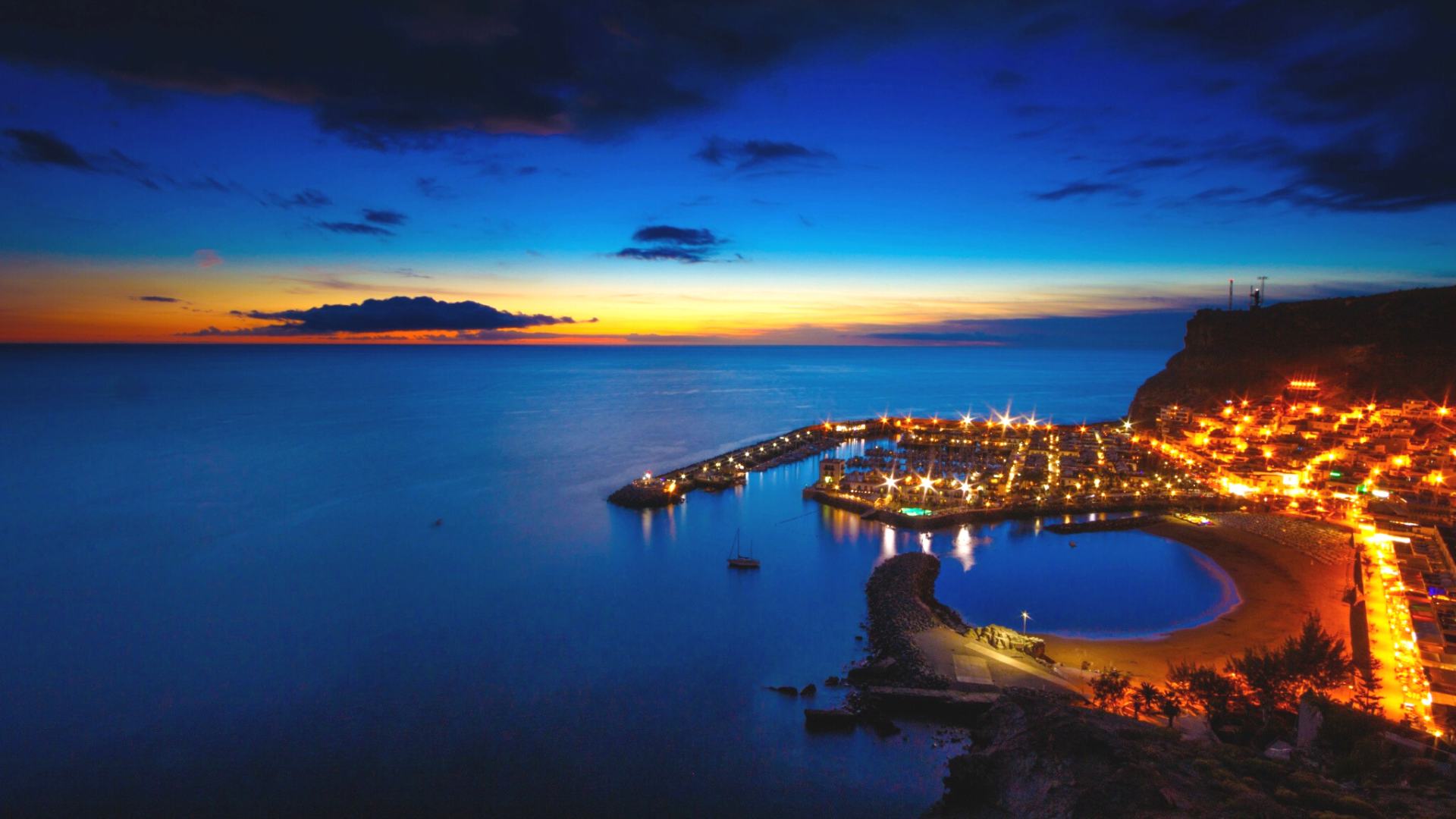 Puerto y Playa de Mogán iluminados al atardecer