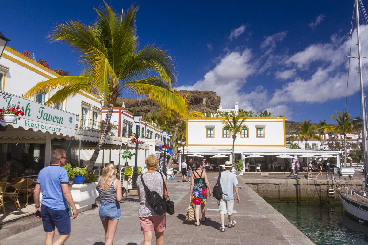 Puerto de Mogán, Gran Canaria, personas caminando por el puerto al lado de los restaurantes y barcos a la derecha